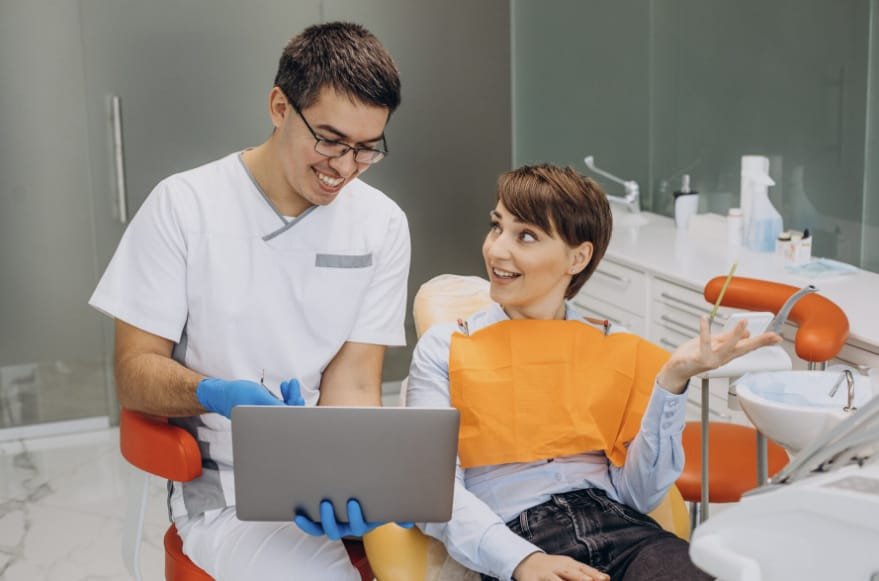 Un paciente sonriente durante una visita al dentista, simbolizando el acceso a servicios dentales de calidad.